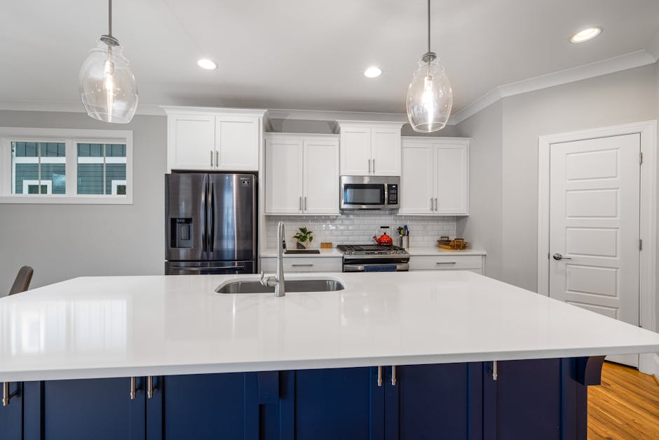 Stylish modern kitchen with a spacious white countertop and stainless steel appliances.